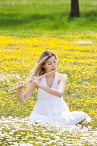 Woman playing flute in flower field
